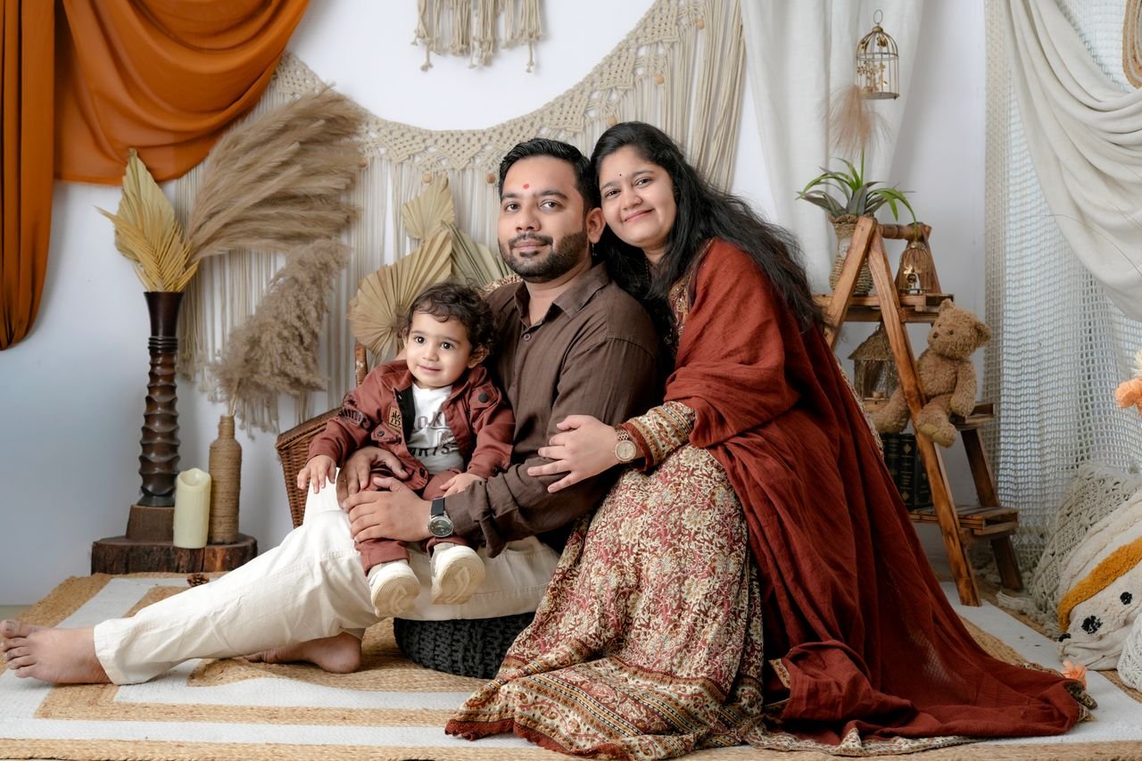 The Art of Drawing Readers In: Your attractive post title goes here A family portrait of a couple with their child in a bohemian style living room setting.