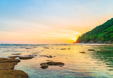 Beautiful sunset over mountain around beach sea ocean and rock for nature vacation background